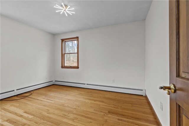 empty room with a baseboard radiator and wood finished floors