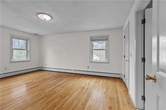 unfurnished room with a baseboard radiator and light wood-style flooring