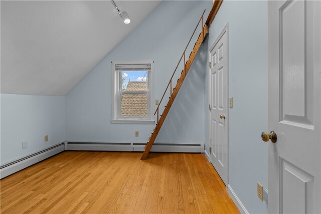 additional living space with light wood-type flooring and vaulted ceiling