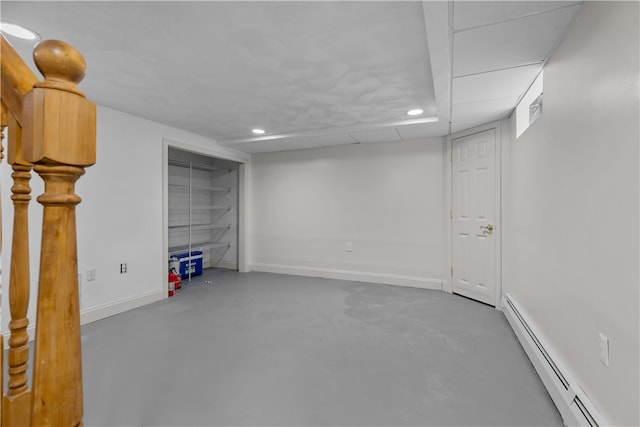 basement with baseboards, a baseboard heating unit, and recessed lighting