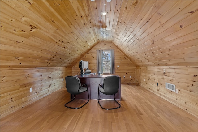 additional living space with lofted ceiling, wooden ceiling, wood walls, wood finished floors, and visible vents