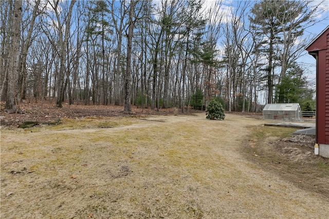 view of yard with a greenhouse and an outdoor structure