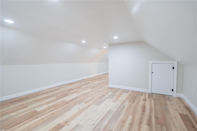 additional living space with light wood finished floors, baseboards, vaulted ceiling, and recessed lighting