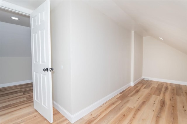 additional living space with vaulted ceiling, baseboards, and wood finished floors