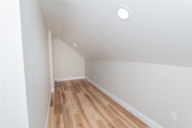 additional living space with lofted ceiling, light wood-style floors, and baseboards