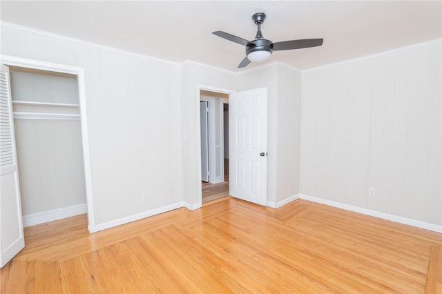 unfurnished bedroom featuring light wood finished floors, baseboards, ornamental molding, and a closet