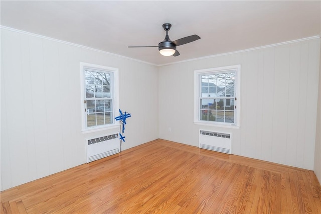 spare room with light wood-type flooring, a wealth of natural light, and radiator