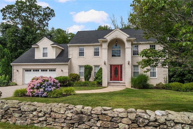 colonial-style house featuring driveway, brick siding, a front lawn, and an attached garage