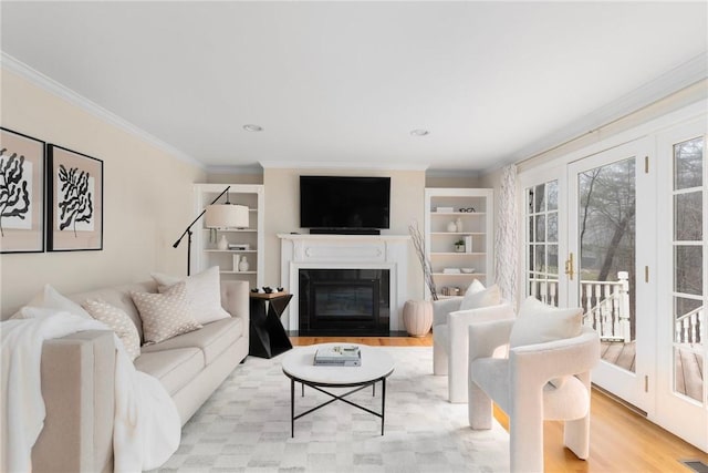 living area featuring light wood finished floors, a fireplace with flush hearth, and ornamental molding