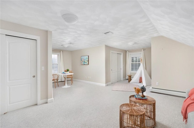 rec room featuring a baseboard radiator, visible vents, carpet flooring, a textured ceiling, and baseboards