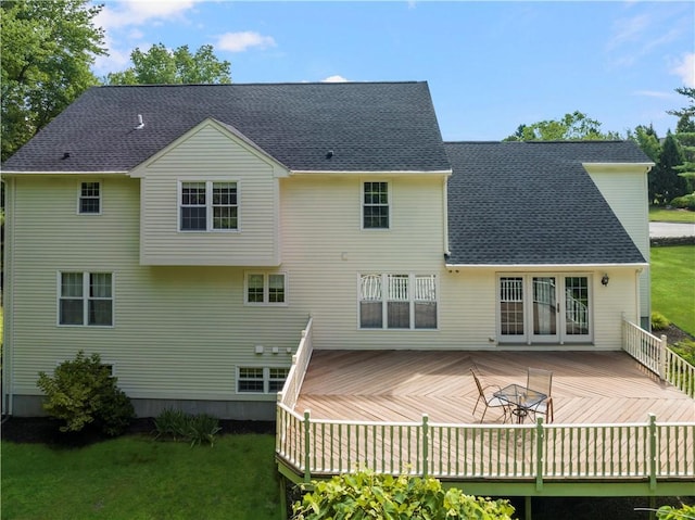 rear view of property featuring a deck, french doors, and roof with shingles