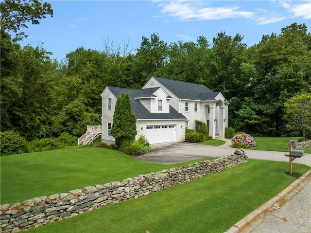 view of front of house with a garage, a front yard, driveway, and stairs