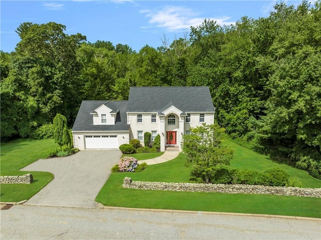 view of front of house featuring a garage, a front yard, and driveway