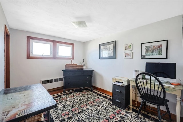 office with radiator heating unit, visible vents, and baseboards