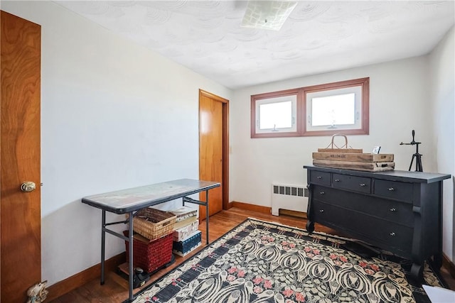 office space featuring radiator, baseboards, and wood finished floors