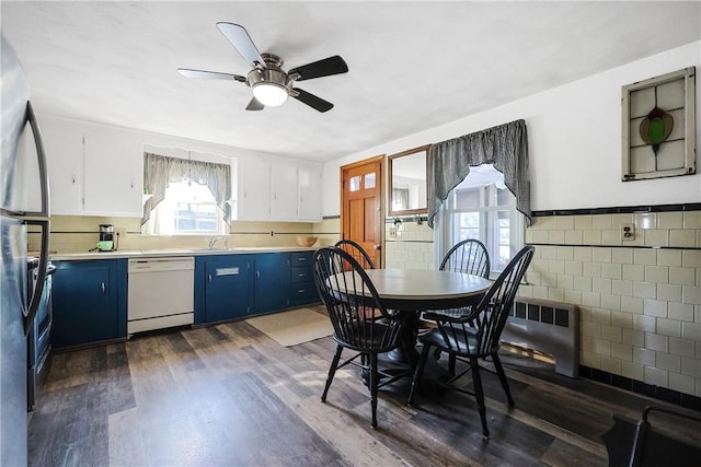 kitchen featuring dishwasher, dark wood-style floors, freestanding refrigerator, light countertops, and blue cabinetry