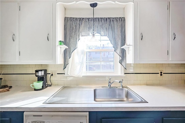 kitchen featuring light countertops, white cabinetry, backsplash, and blue cabinetry