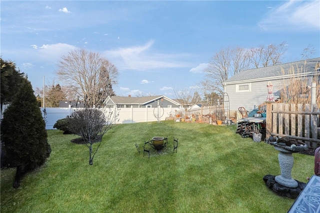 view of yard with a fenced backyard and a fire pit