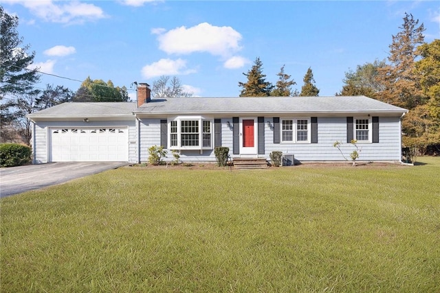 ranch-style home with aphalt driveway, a chimney, a garage, and a front lawn