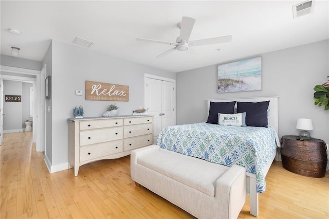 bedroom with a closet, baseboards, visible vents, and light wood finished floors