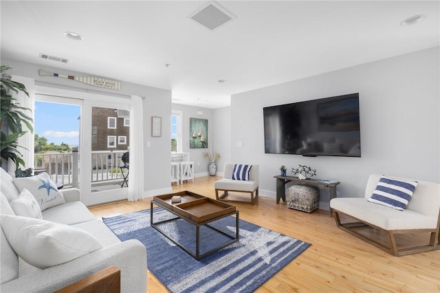 living area with light wood finished floors, baseboards, and visible vents