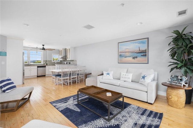 living area featuring light wood-style flooring and visible vents