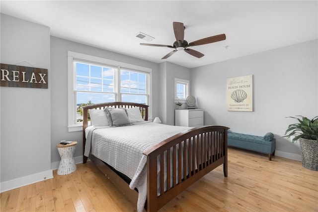 bedroom featuring baseboards, multiple windows, visible vents, and light wood-style floors