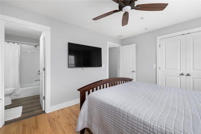 bedroom featuring ensuite bathroom, a ceiling fan, baseboards, a closet, and light wood-type flooring