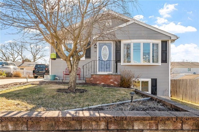 bungalow-style home with a front yard and fence