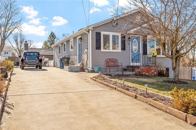 view of front of property featuring driveway and fence