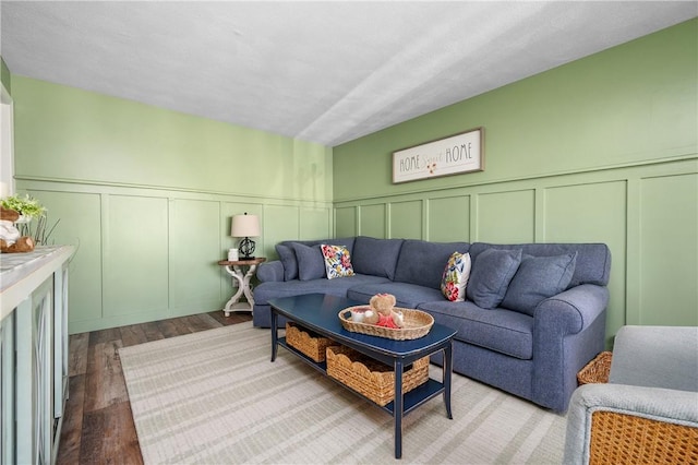 living room with a decorative wall and wood finished floors