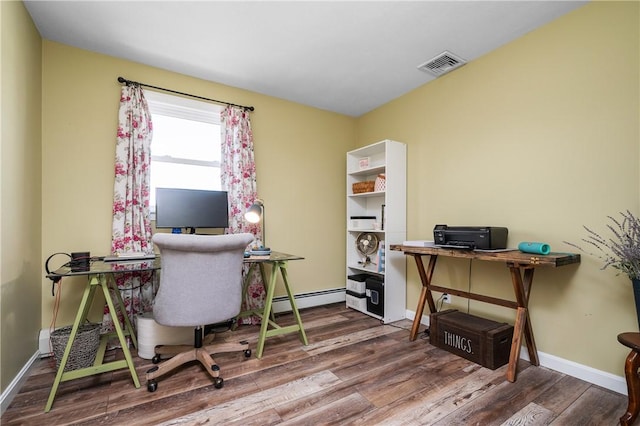 office featuring a baseboard heating unit, wood finished floors, visible vents, and baseboards