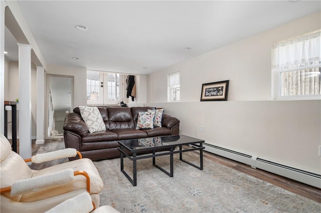 living area featuring french doors, baseboard heating, and wood finished floors