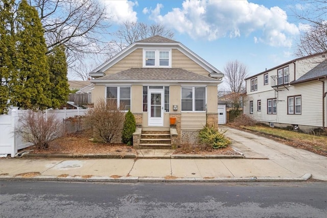 view of front of property with entry steps, a garage, a shingled roof, fence, and driveway