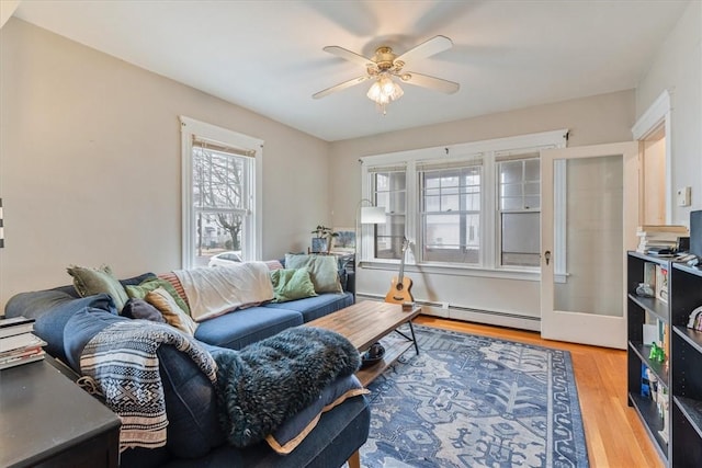 living area with a baseboard radiator, wood finished floors, and a ceiling fan