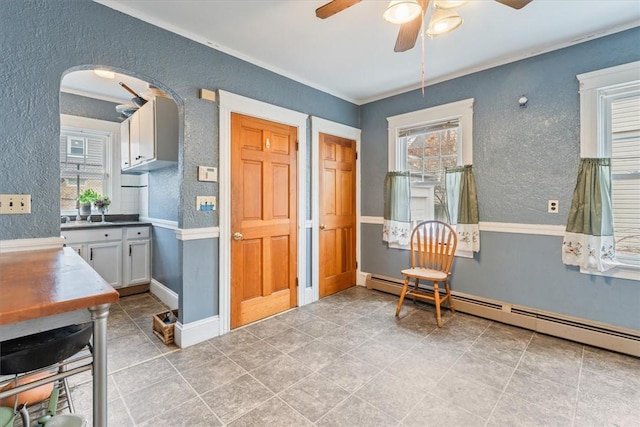 interior space with plenty of natural light, a baseboard radiator, and a textured wall