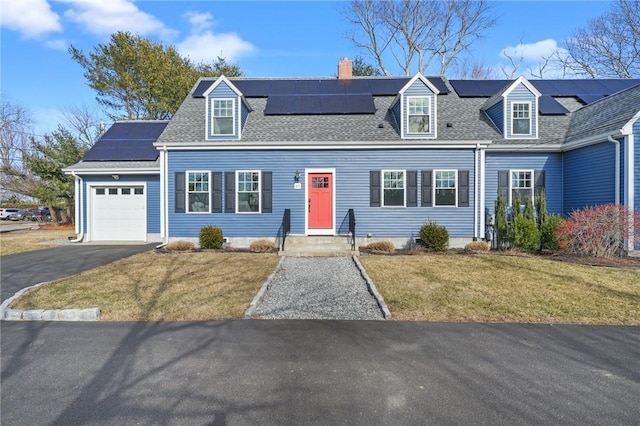 new england style home with a garage, driveway, roof with shingles, and a front lawn