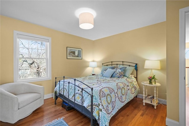 bedroom featuring baseboards and wood finished floors