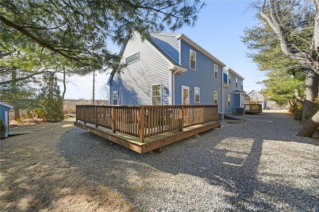 rear view of house with cooling unit and a deck