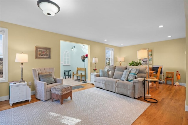 living area featuring recessed lighting, baseboards, and wood finished floors