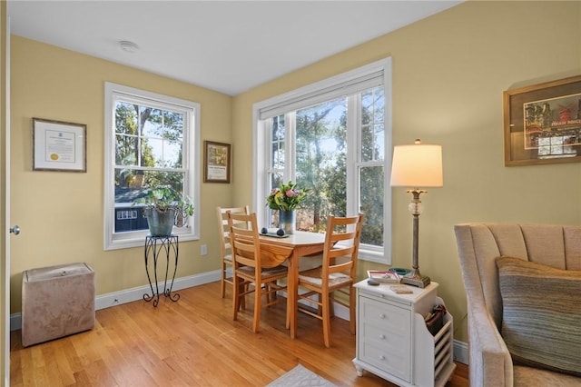 dining space with plenty of natural light, baseboards, and light wood finished floors