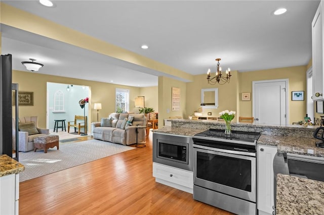 kitchen featuring open floor plan, recessed lighting, stainless steel appliances, and light wood-style floors