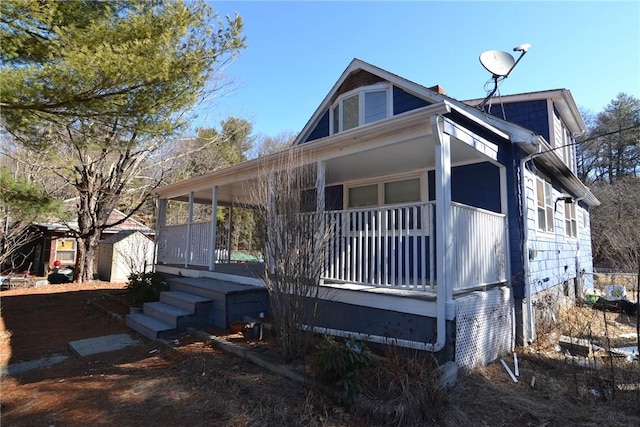 view of front of home with a porch and an outdoor structure