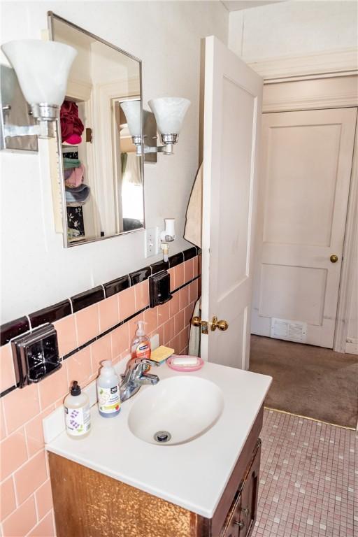 bathroom with vanity, tile walls, and visible vents