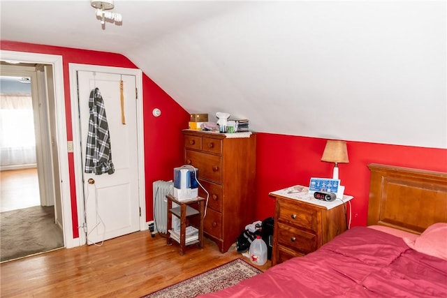 bedroom with wood finished floors and vaulted ceiling