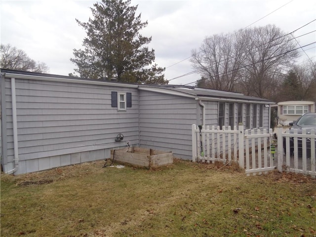 rear view of house featuring fence and a yard