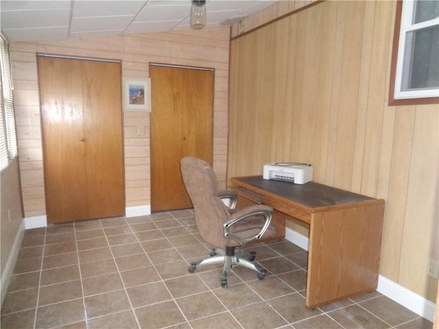 home office with lofted ceiling, tile patterned flooring, and wooden walls