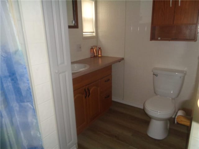 full bathroom featuring vanity, toilet, and wood finished floors