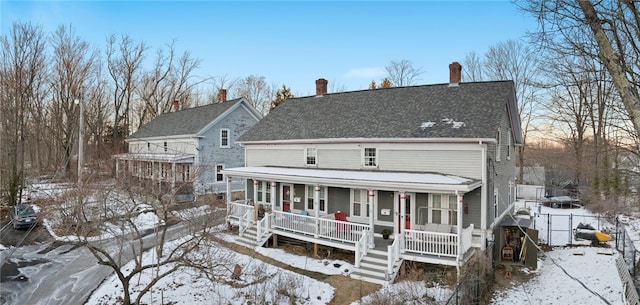 view of front of house featuring a shingled roof, a gate, fence, and a porch