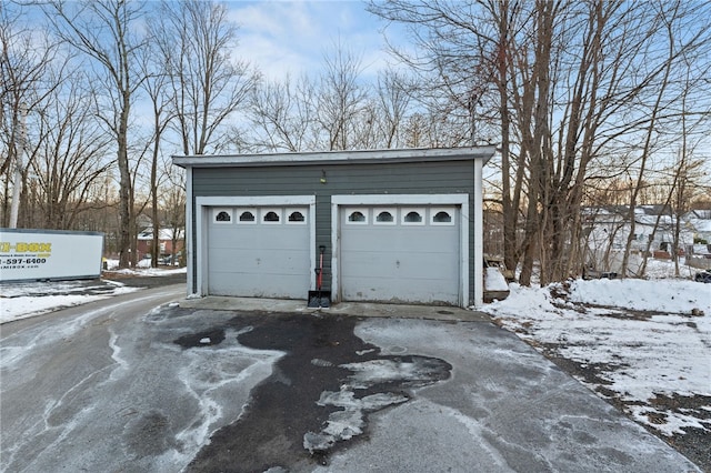 snow covered garage featuring a garage